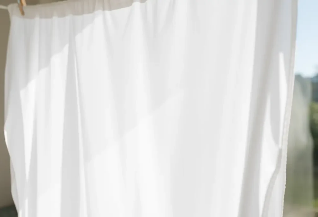 Folha branca pendurada ao varal com luz natural